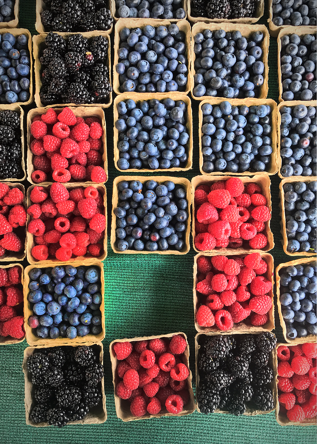 variety of berries on farmstand table
